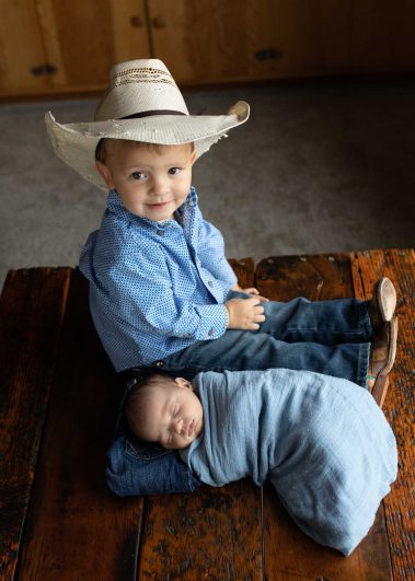 little cowboy with newborn baby